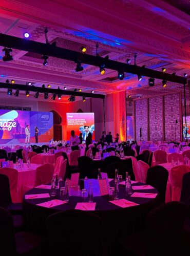 Corporate event production setup in Dubai ballroom with LED stage wall, professional lighting rig, and banquet seating by Pure Magic Events