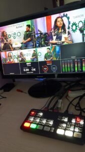 A production monitor displaying a multi-camera live stream of a corporate discussion panel, controlled by a professional ATEM video switcher.